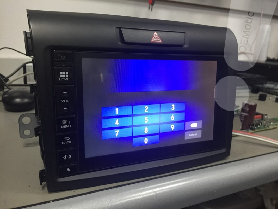 Zablokowane radio Honda Connect w wersji z uchylanym panelem (winda) i fizycznymi przyciskami, z ekranem proszącym o kod.