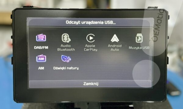 Ekran radia Kia Sportage z komunikatem Odczyt urządzenia USB i ikonami źródeł audio DAB FM Bluetooth CarPlay Android